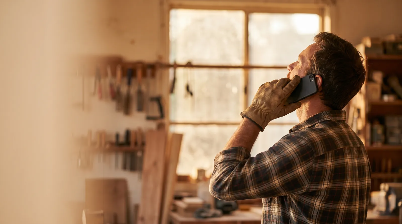 A local tradesperson taking a phone call in their workshop